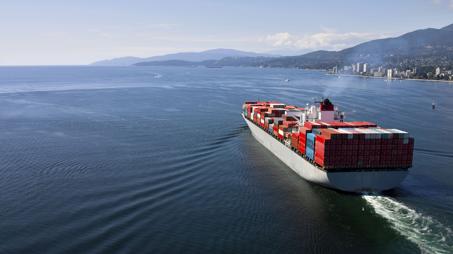 Cargo ship loaded with containers close to coast