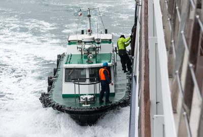 People on tug boat climbing onboard