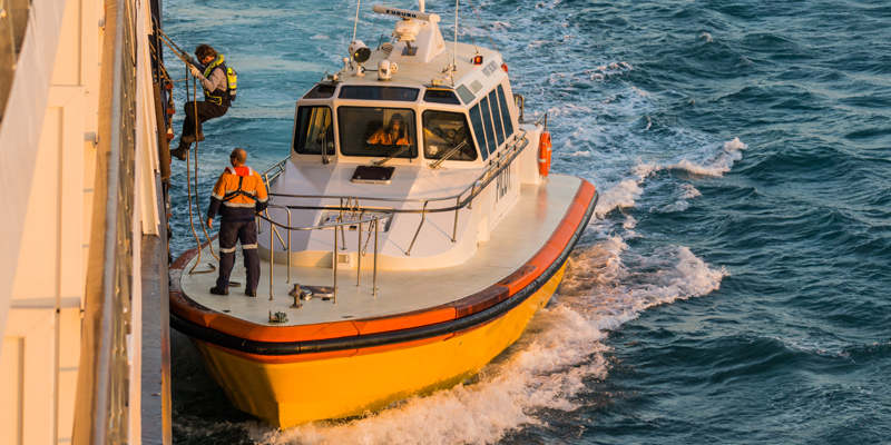 Image of person climbing onboard a vessel.
