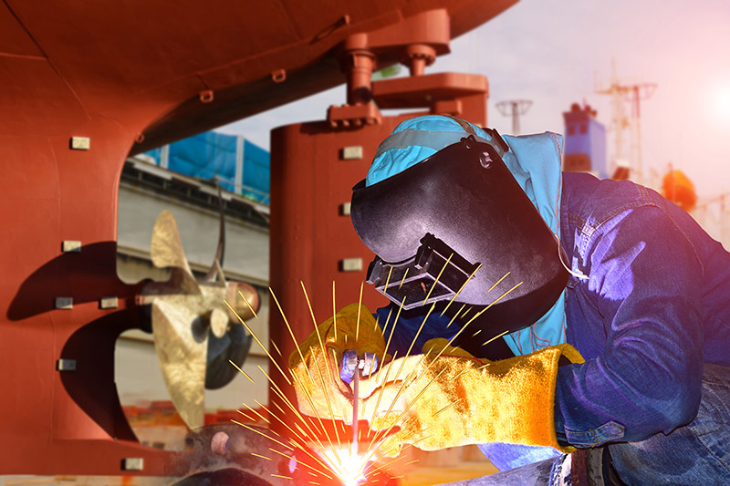 Crew member welding on a vessel